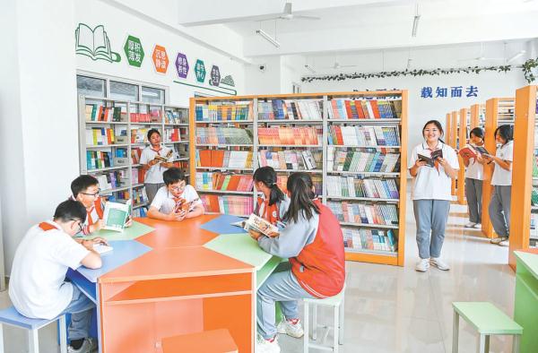 在北京实验学校三河校区，学生们正在阅览室读书。